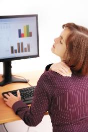 women with back pain at computer
